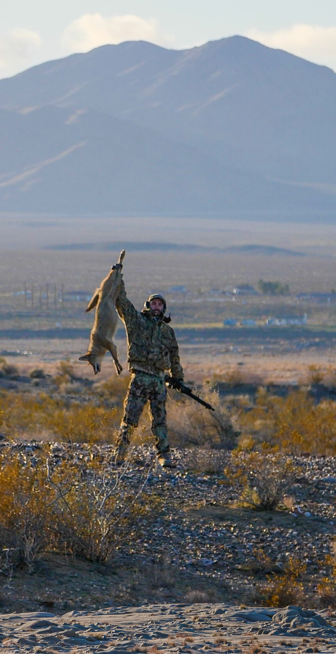 Clayton Holliday holding up a coyote